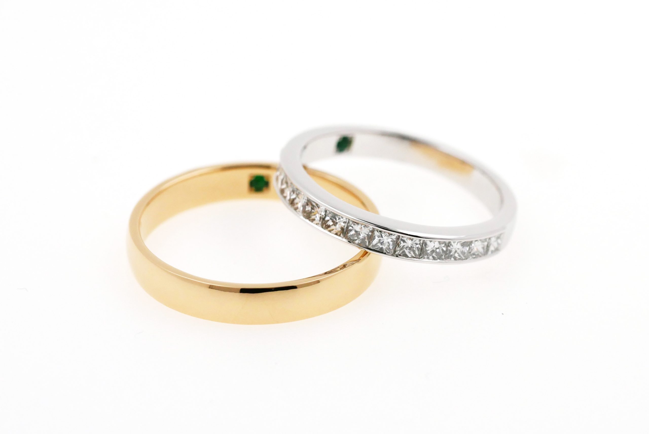 Duos d'alliances en or jaune et en or blanc sertie de diamants taille princesse pour lesquelles un grenat tsavorite a été serti à l'intérieur de l'anneau