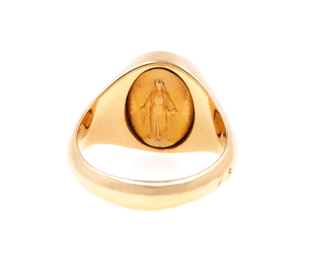 Miraculous medal set under a heraldic yellow gold signet light