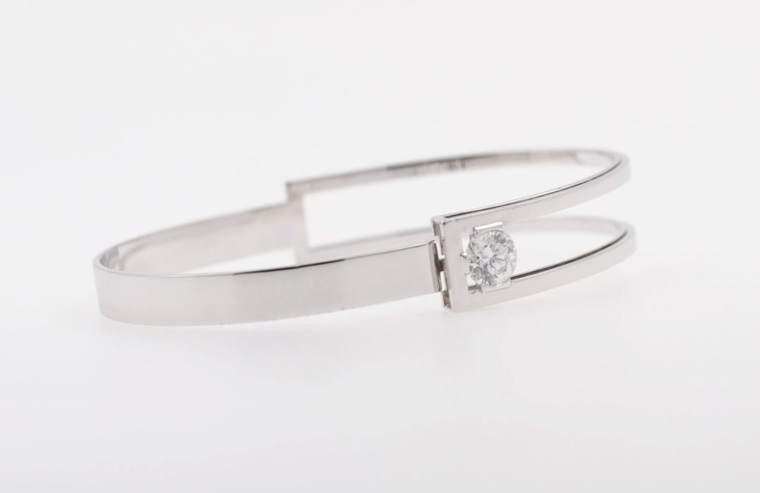 Bracelet jonc ouvrant asymétrique en or blanc serti de diamants, bijou de créateur au design moderne et graphique, Bijouterie Griffon.