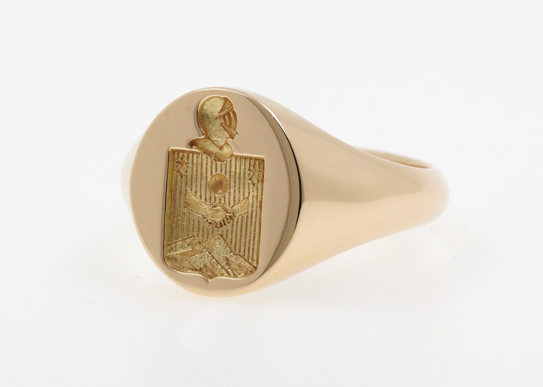 Chevalière armoriée en or jaune 18 carats avec gravure héraldique personnalisée comprenant un écu surmonté d'un heaume (casque) et de lambrequins, création artisanale Bijouterie Griffon.