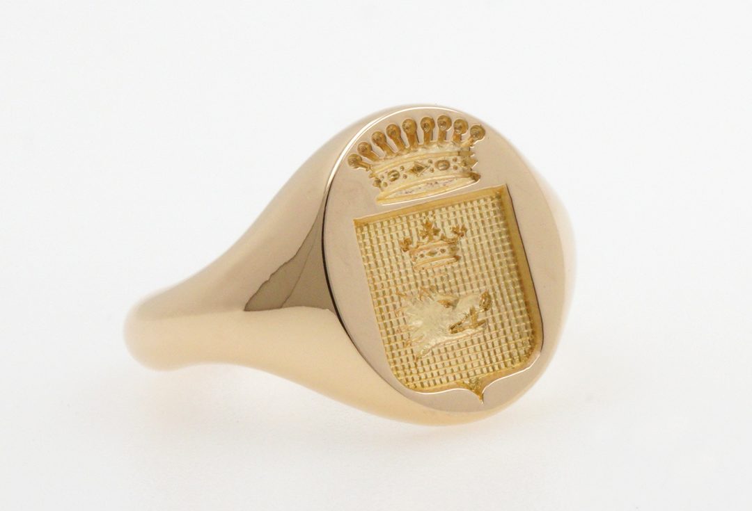 Chevalière armoriée en or jaune avec gravure héraldique personnalisée d'un écu surmonté d'une couronne de comte, bague de prestige artisanale Bijouterie Griffon.