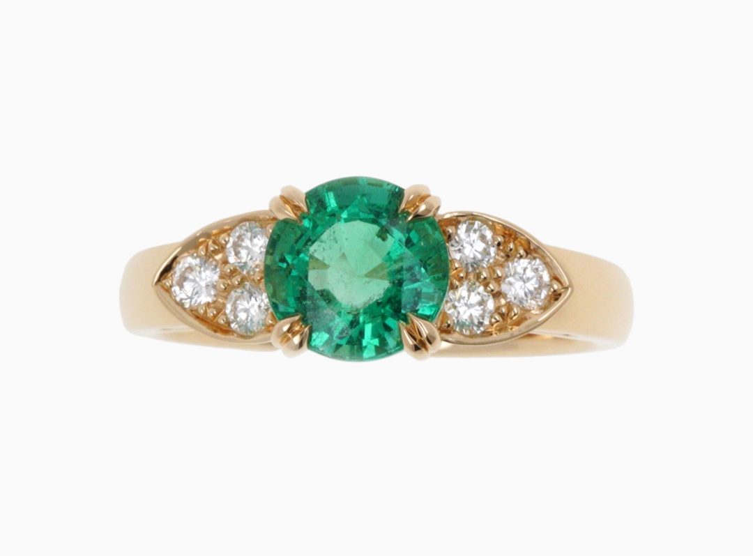 Bague de fiançailles sertie d'une émeraude centrale et diamants avec doubles griffes.