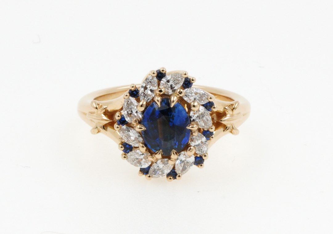 Bague de fiançailles or jaune sertie de saphirs et diamants avec motif fleur de lys.