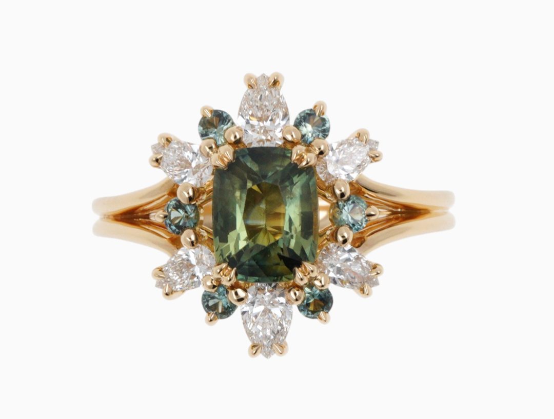 Bague de fiançailles avec saphir vert taille poire et diamants en forme de fleur de lys.