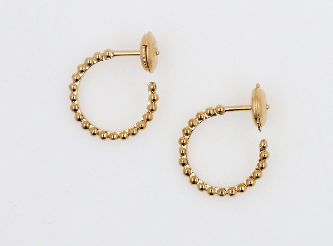 Boucles d'oreilles créoles en or jaune travaillées avec une bille sertie d'un diamant.