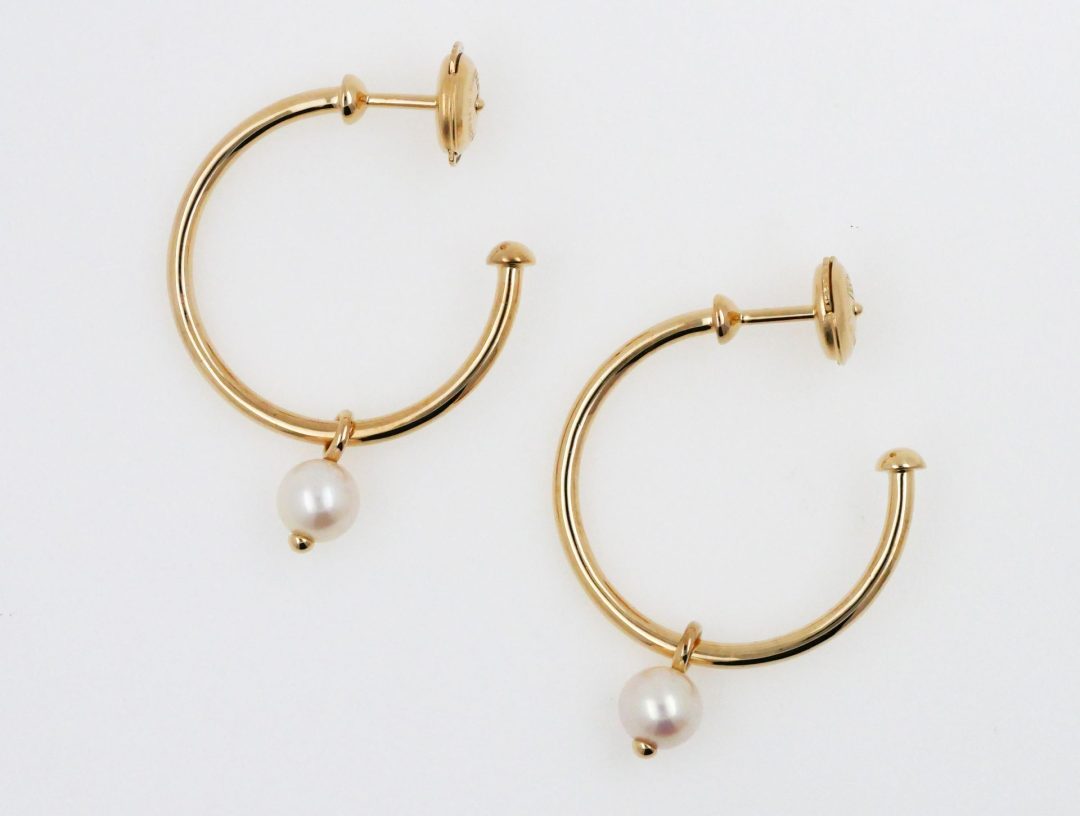 Boucles d'oreilles créoles en or jaune avec perle de culture blanche mobile.