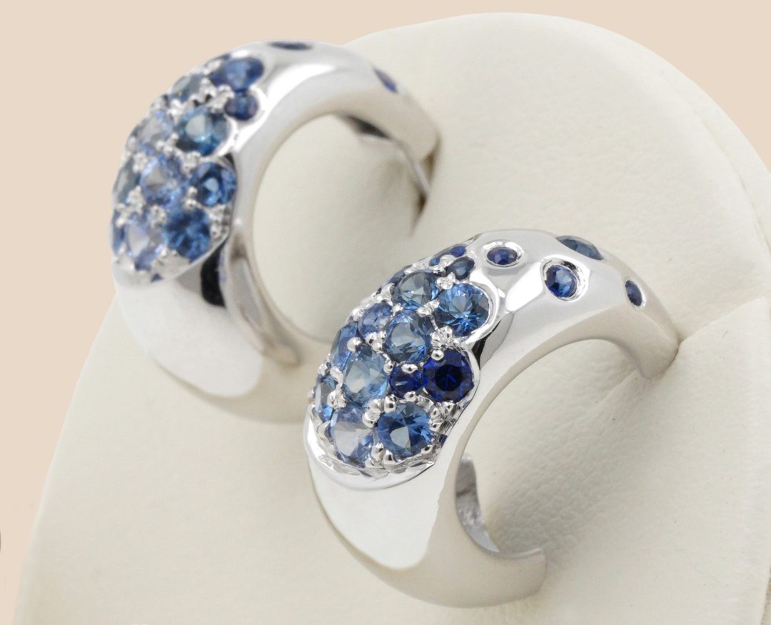 Boucles d'oreilles demi-créoles en or blanc avec un dégradé de saphirs bleus et diamants.