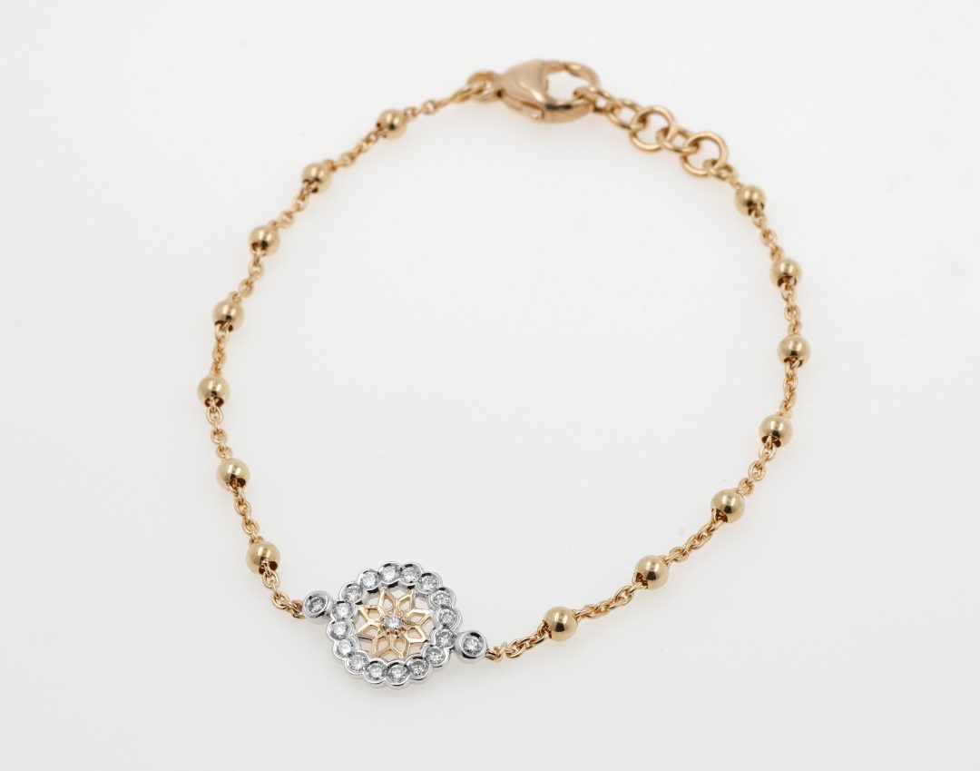 Bracelet en or jaune et blanc serti d'une bille en diamant.