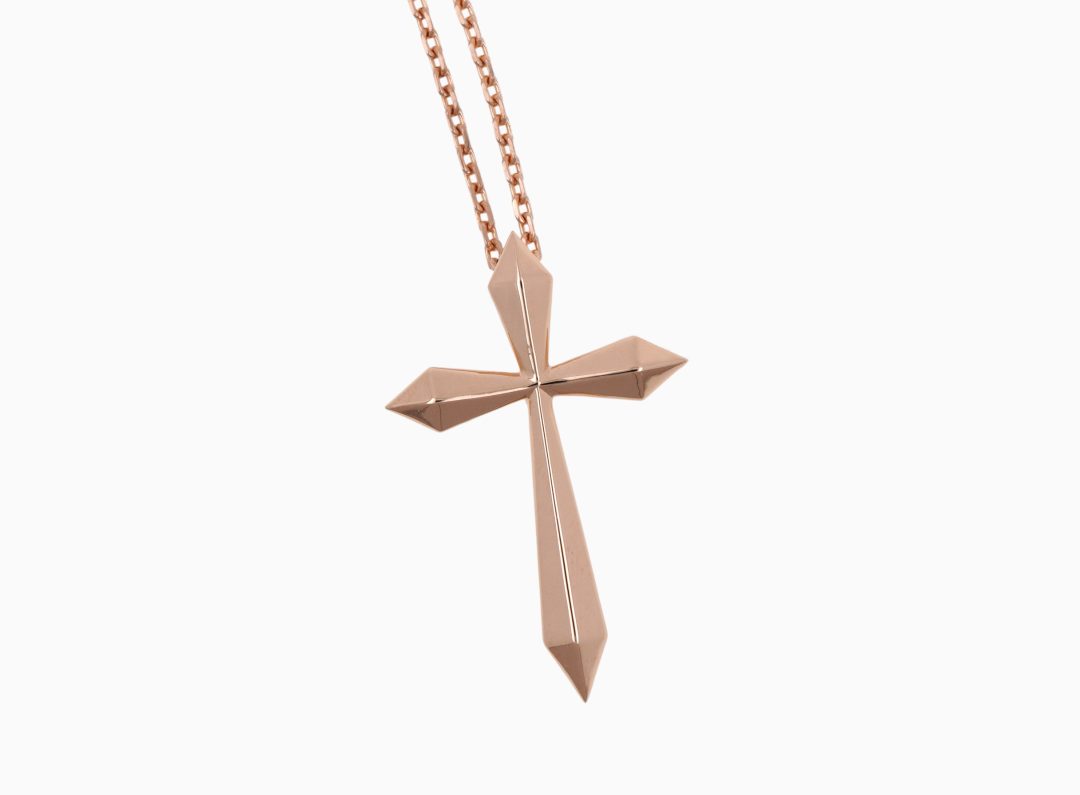 Pendentif en forme de croix sculptée en or rose.
