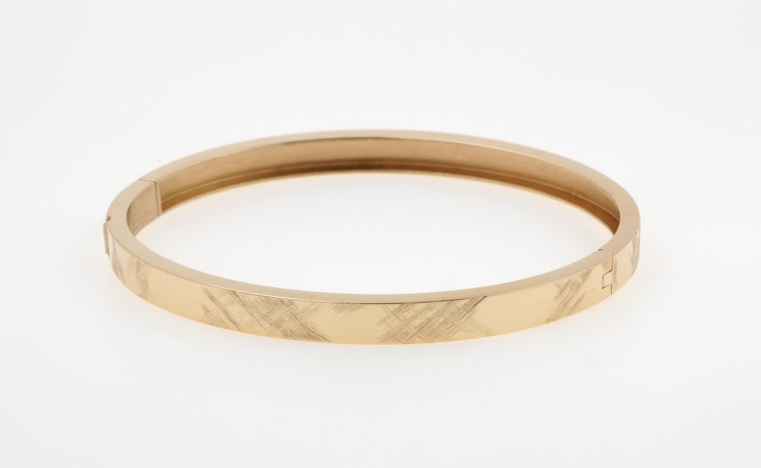 Bracelet jonc en or jaune avec fermoir invisible et effet de matière brossé.