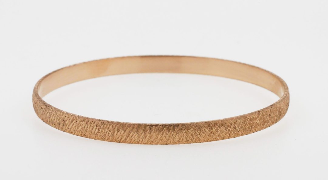 Bracelet jonc en or rose avec effet de matière ciselé.