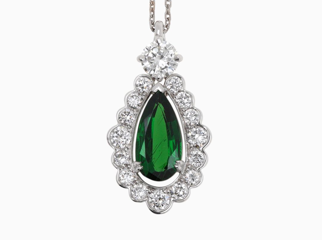 Pendentif or blanc serti d'un grenat tsavorite poire et entourage diamants.